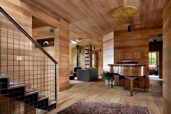 The hallway serves as the home’s focal point, with the staircase on the left designed specifically for the home, integrating natural materials.